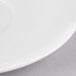 A white bone china saucer with a curved edge.