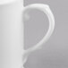 A close-up of a white Reserve by Libbey bone china coffee mug with a handle.