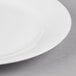 A close up of a Reserve by Libbey International bone china dinner plate with a white center and white rim.