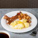 A Reserve by Libbey bone china plate with bacon, eggs and hash browns on a table with a cup of coffee.