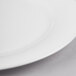 A close-up of a white Reserve by Libbey bone china round plate with a white rim.