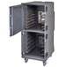 A large metal Cambro food holding cabinet with open doors and wheels.