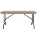 A rectangular Correll mocha granite folding table with brown legs.