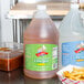 A Woeber's gallon jug of cider vinegar on a counter with a group of french fries.