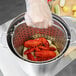A Vollrath fryer pot with a strainer cooking lobsters.