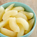 A bowl of Regal sliced pears in light syrup on a wooden table.