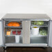 A Traulsen stainless steel undercounter refrigerator with food inside.