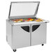 A Turbo Air stainless steel refrigerated sandwich prep table with glass lids on top.
