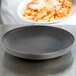 A plate of pasta with sauce and cheese served on a Dinex graphite grey insulated meal delivery base.