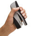 A person's hand using a Swingline Optima Grip stapler.
