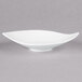 An Arcoroc white porcelain bowl with a small leaf design.