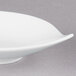 An Arcoroc round white porcelain bowl with a curved edge.
