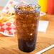 A Cambro slate blue plastic tumbler filled with soda and ice on a table with fries.