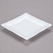 A bright white square porcelain plate with a bamboo pattern on the rim.