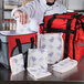 A chef in a white coat using a Nordic foam brick cold pack to put food in a white bag.