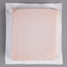 A plastic wrapped pink square foam brick cold pack.