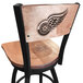 A black steel Holland Bar Stool bar height swivel chair with a maple back and seat and a Detroit Red Wings logo laser engraved on the back.