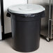A white Continental lid on a gray round trash can.