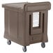A Cambro dual access meal delivery cart with wheels for brown plastic containers.