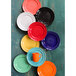 A group of colorful Tuxton Concentrix plates on a table.
