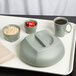 A grey plastic tray with a Cambro Harbor Collection insulated mug of coffee on it and a plate of food.