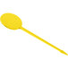A yellow plastic oval pick with a long handle.