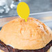 A hamburger with a yellow plastic toothpick on top.