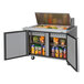 A Turbo Air TST-48SD refrigerated sandwich prep table with food inside.