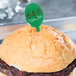 A hamburger with a green plastic WNA Comet Spirit pick in it.