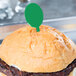 A hamburger with a green plastic oval pick on top.