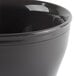 A close-up of a Cambro smoked metal insulated plastic bowl with a black lid.
