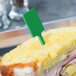A sandwich with a WNA Comet green plastic rectangular pick in the middle.