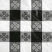 A black and white checkered vinyl table cover with flowers on a table.