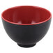 A black bowl with red on the inside and a red rim.