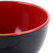 A black melamine bowl with a red interior.