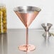 A GET copper martini glass filled with a cocktail garnished with olives.