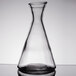 A clear glass beaker with a black base.