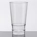 A stackable clear plastic mixing glass with a rim on a table.