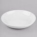 A Libbey Porcelain low bowl in white on a gray surface.