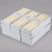 A stack of white boxes filled with ivory Hyoola taper candles.