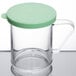A clear Cambro polycarbonate shaker with a green lid.