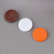Three different colored plastic tabs: white, orange with a lightning bolt, and brown with an arrow.