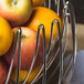 A Clipper Mill suspended wire basket filled with apples and oranges.