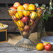 A metal basket filled with lemons and apples.