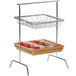 A Clipper Mill chrome plated iron square wire basket on a metal rack with food in it.