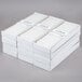 A stack of boxes of white Hyoola 12" taper candles.
