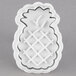 A white plastic pineapple shaped cookie cutter.