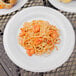 A Carlisle white melamine plate with pasta and shrimp on it.