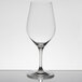 A clear Chef & Sommelier Bordeaux wine glass on a table with a reflection.