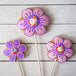 A group of pink and purple cookies with flower shapes cut out of them.